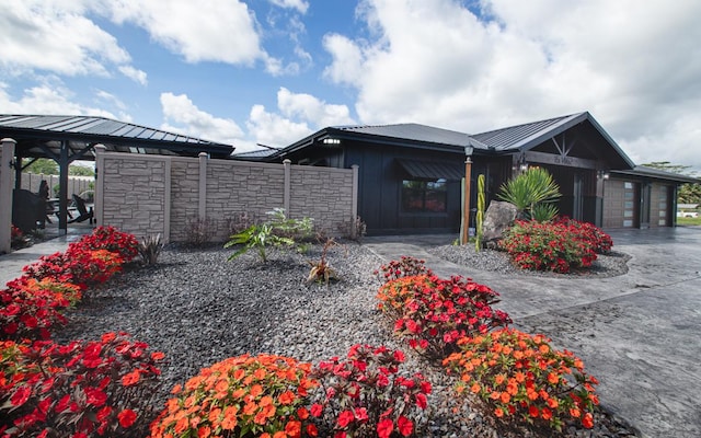 15-1462 13th Ave, Keaau, HI 96749 - view of side of property with metal roof, an attached garage, stone siding, and a standing seam roof