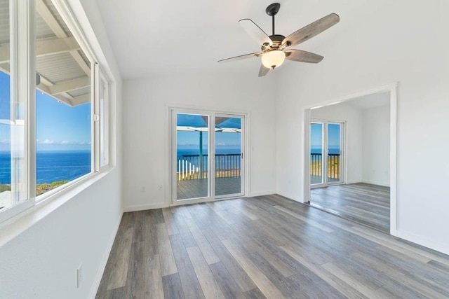 87-3210 Guava Rd, Captain Cook, HI 96704 - empty room with wood finished floors, a ceiling fan, lofted ceiling, baseboards, and a water view
