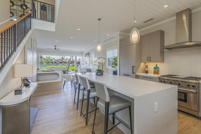 73-4780 Hinahina Rd Unit 24, Kailua-Kona, HI 96740 - kitchen with high end stove, wall chimney exhaust hood, gray cabinetry, a kitchen island, and open floor plan