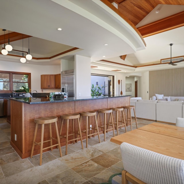 81-6641 Auamo Pl, Kealakekua, HI 96750 - kitchen featuring stainless steel appliances, stone tile flooring, dark countertops, lofted ceiling, and brown cabinetry