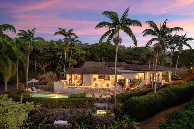 81-6641 Auamo Pl, Kealakekua, HI 96750 - back of property at dusk featuring a patio area and stucco siding