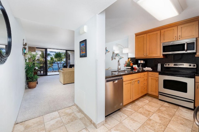 75-6106 Alii Dr Unit 311, Kailua-Kona, HI 96740 - kitchen featuring stainless steel appliances, a sink, decorative backsplash, light colored carpet, and open floor plan
