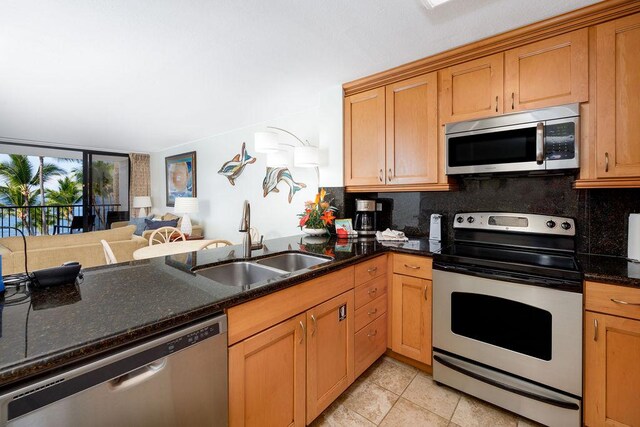 75-6106 Alii Dr Unit 311, Kailua-Kona, HI 96740 - kitchen with stainless steel appliances, a sink, backsplash, and dark stone countertops