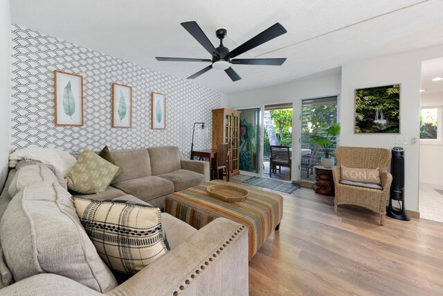 78-6800 Alii Dr Unit 20, Kailua-Kona, HI 96740 - living area featuring wallpapered walls, wood finished floors, an accent wall, plenty of natural light, and ceiling fan