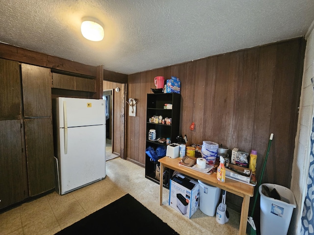 322 Ohai St Unit 2, Hilo, HI 96720 - kitchen with freestanding refrigerator, wood walls, a textured ceiling, and light flooring