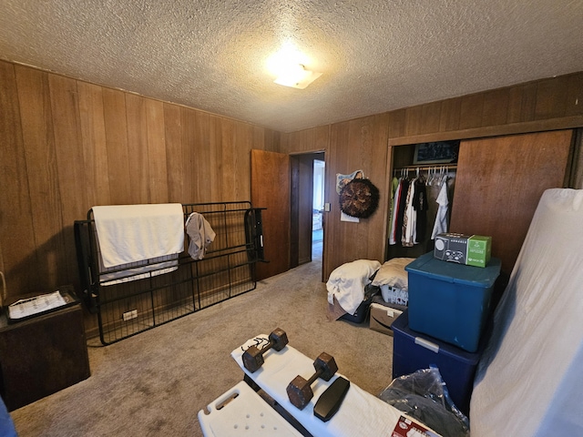 322 Ohai St Unit 2, Hilo, HI 96720 - bedroom with carpet flooring, wooden walls, a closet, and a textured ceiling