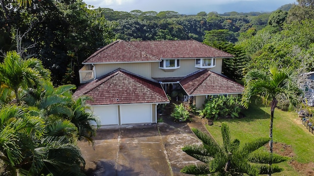 5841 Haaheo St, Kapaa, HI 96746 - view of front of property with driveway, a wooded view, a front lawn, and an attached garage