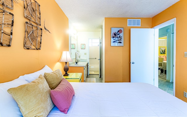 360 Kauila St Unit 201, Hilo, HI 96720 - bedroom with connected bathroom, a textured ceiling, and a sink