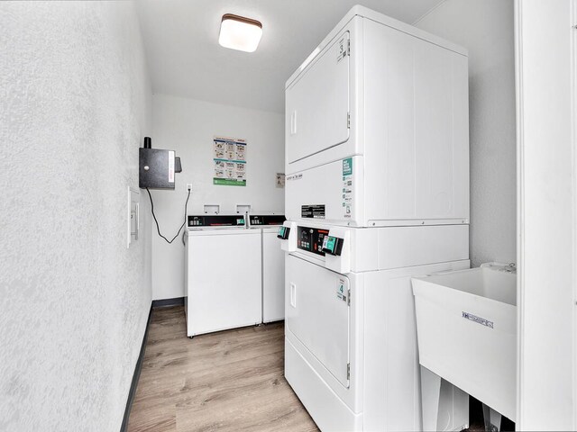307 Lehua St Unit 22, Hilo, HI 96720 - community laundry with stacked washing machine and dryer, light wood-style flooring, and washer and clothes dryer