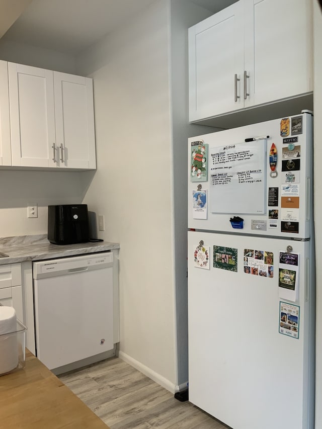 75-5873 Walua Rd Unit 118, Kailua-Kona, HI 96740 - kitchen featuring white appliances, light wood-style floors, white cabinetry, light countertops, and baseboards