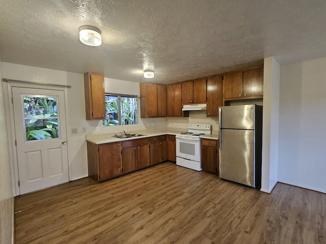 37-A Noio Ln Unit 2, Hilo, HI 96720 - kitchen with white electric stove, freestanding refrigerator, under cabinet range hood, dark wood-style flooring, and light countertops