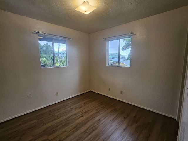 37-A Noio Ln Unit 2, Hilo, HI 96720 - unfurnished room featuring dark wood-style flooring, baseboards, a textured ceiling, and a textured wall