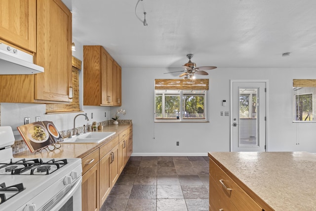 12-7046 Kehauopuna St, Pahoa, HI 96778 - kitchen featuring gas range gas stove, a sink, ceiling fan, baseboards, and stone tile floors