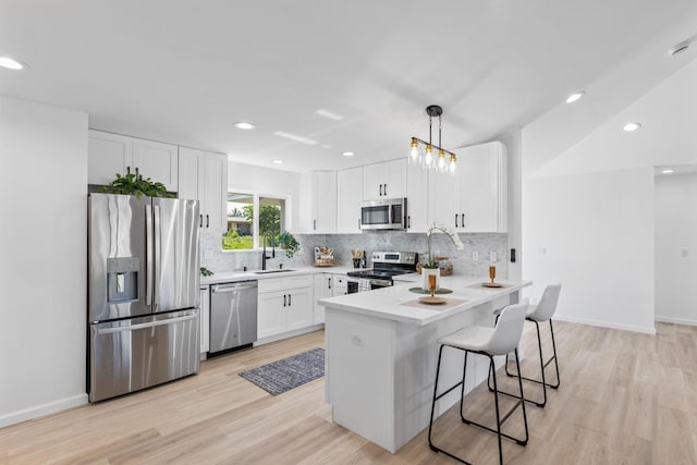 15-1499 23rd Ave, Keaau, HI 96749 - kitchen featuring appliances with stainless steel finishes, a sink, a peninsula, backsplash, and light wood-style floors