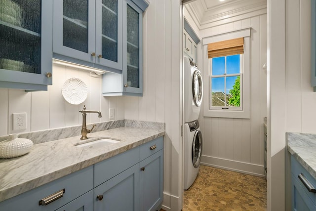 5086 Lau Nahele St, Koloa, HI 96756 - laundry area featuring stacked washer / drying machine, cabinet space, crown molding, and a decorative wall