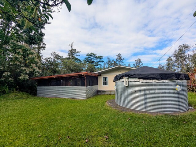 14-3426 Molokai Rd, Pahoa, HI 96778 - back of property with a lawn and a sunroom