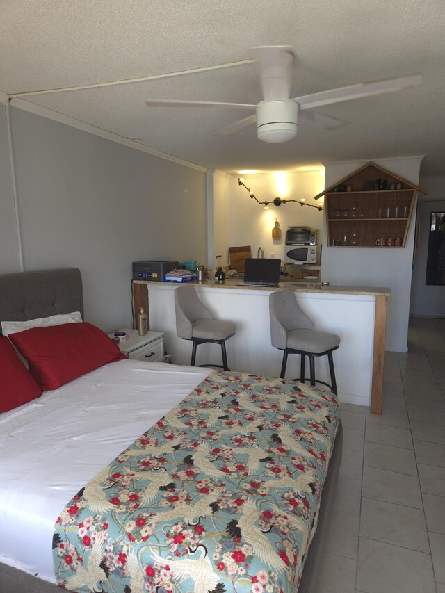 75-5680 Kuakini Hwy Unit 309, Kailua-Kona, HI 96740 - bedroom featuring ornamental molding, a textured ceiling, tile patterned flooring, and a ceiling fan