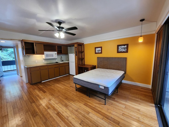 400 Hualani St Unit 3214, Hilo, HI 96720 - bedroom featuring freestanding refrigerator, light wood finished floors, baseboards, a sink, and a ceiling fan