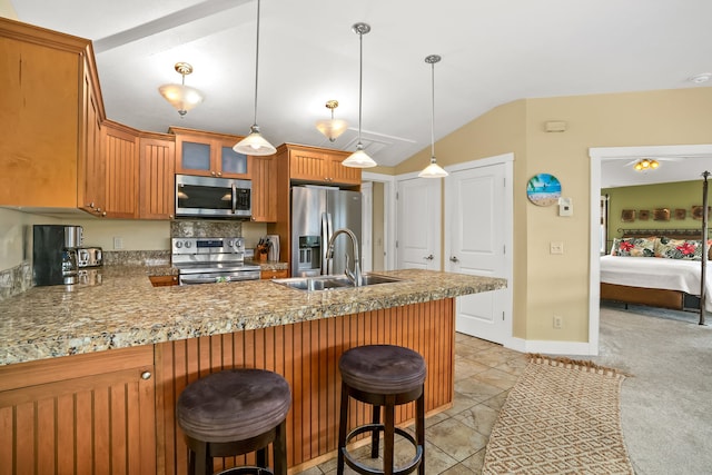 4771 Pepelani Lp Unit 1521, Princeville, HI 96722 - kitchen with appliances with stainless steel finishes, lofted ceiling, a peninsula, a sink, and brown cabinetry