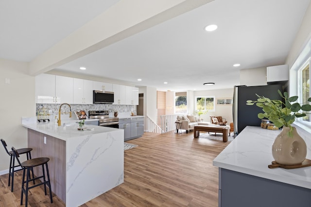 1577 Maunakai St, Hilo, HI 96720 - kitchen featuring appliances with stainless steel finishes, light stone countertops, a peninsula, decorative backsplash, and recessed lighting