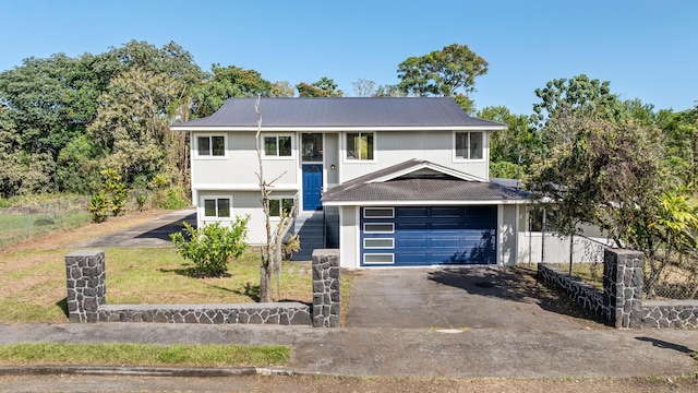 1577 Maunakai St, Hilo, HI 96720 - raised ranch with driveway, metal roof, an attached garage, and stairway