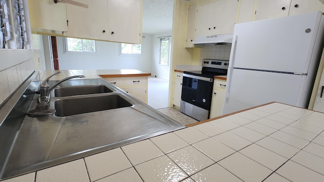 90 Palua Loop, Hilo, HI 96720 - kitchen with stainless steel electric range oven, freestanding refrigerator, under cabinet range hood, decorative backsplash, and a sink