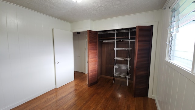 90 Palua Loop, Hilo, HI 96720 - unfurnished bedroom with wood-type flooring, multiple windows, a closet, and a textured ceiling