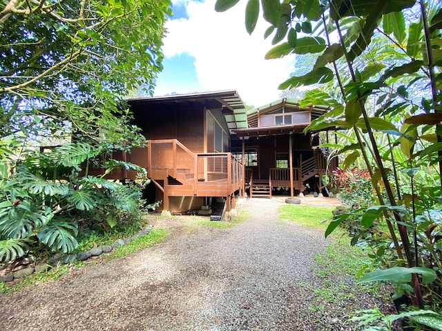 14-3527 Hawaii Rd, Pahoa, HI 96778 - back of property with a wooden deck, a sunroom, and stairway