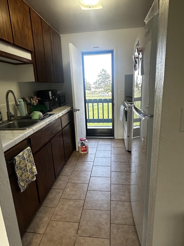 199 Kehaulani St Unit 3, Hilo, HI 96720 - kitchen with tile counters, a sink, white electric stove, and light tile patterned floors