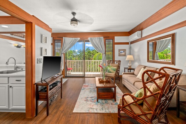 2253 Poipu Rd Unit 411, Koloa, HI 96756 - living room with a ceiling fan, a wall mounted AC, and dark wood-type flooring