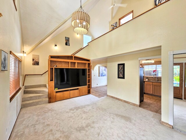 726-A Waianuenue Ave, Hilo, HI 96720 - unfurnished living room with high vaulted ceiling, carpet floors, a chandelier, a sink, and baseboards
