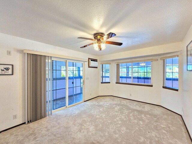 726-A Waianuenue Ave, Hilo, HI 96720 - carpeted spare room with an AC wall unit, a ceiling fan, baseboards, and a textured ceiling