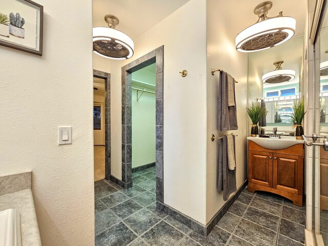726-A Waianuenue Ave, Hilo, HI 96720 - full bathroom featuring vanity, a textured wall, a spacious closet, and baseboards