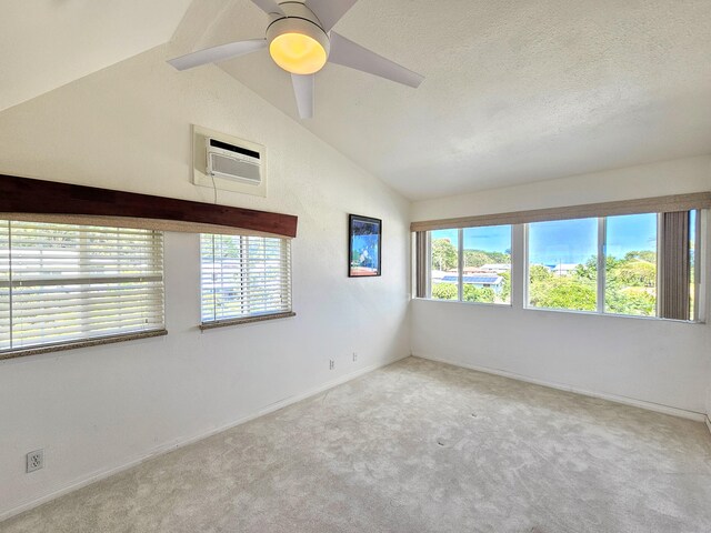 726-A Waianuenue Ave, Hilo, HI 96720 - carpeted spare room with vaulted ceiling, an AC wall unit, ceiling fan, baseboards, and a textured ceiling