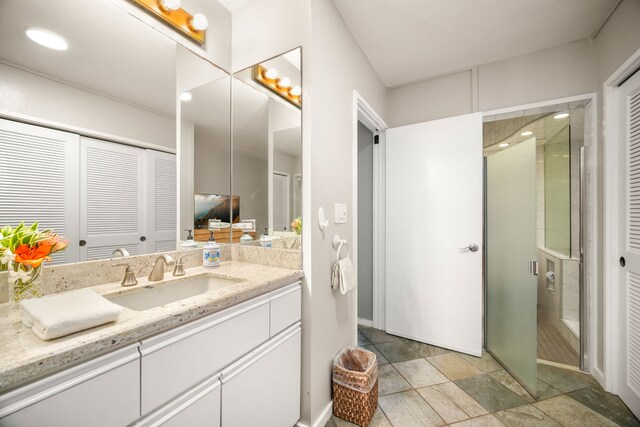 1677 Pee Rd Unit B2, Koloa, HI 96756 - full bathroom with vanity, a stall shower, a closet, stone finish flooring, and baseboards