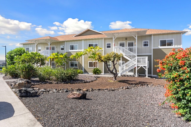 73-1101 Nuuanu Pl Unit D204, Kailua-Kona, HI 96740 - view of front of property with board and batten siding, stairway, and roof with shingles
