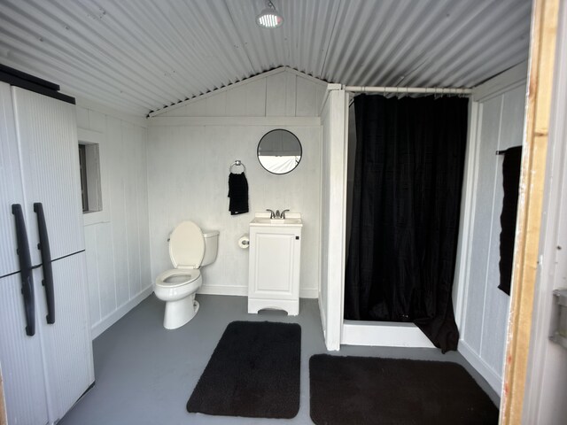 16-1896 Uhini Ana Rd, Mountain View, HI 96760 - bathroom featuring toilet, a shower with shower curtain, vaulted ceiling, vanity, and concrete floors