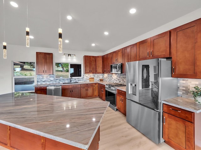 94-5797 Kahiki St, Naalehu, HI 96772 - kitchen featuring stainless steel appliances, tasteful backsplash, a sink, pendant lighting, and light wood finished floors