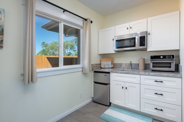 68-3635 Haena St, Waikoloa, HI 96738 - kitchen featuring stainless steel appliances, a sink, white cabinets, light stone countertops, and baseboards