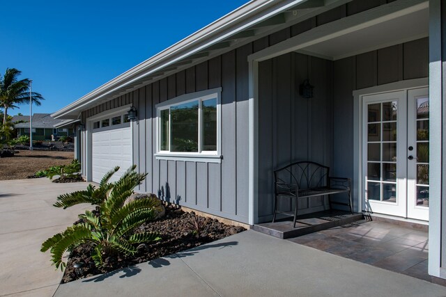 68-3635 Haena St, Waikoloa, HI 96738 - property entrance featuring french doors, board and batten siding, a garage, and concrete driveway