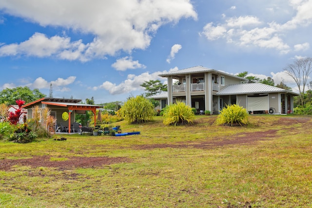 15-2000 5th Ave, Keaau, HI 96749 - rear view of house featuring a lawn, metal roof, and a balcony