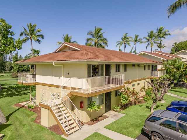 78-7054 Kamehameha Iii Rd Unit 803, Kailua-Kona, HI 96740 - view of front of house featuring stairway, a tiled roof, a front lawn, and stucco siding