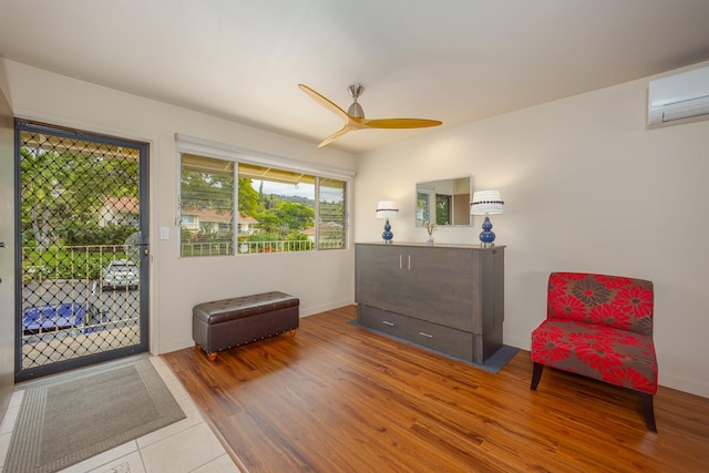 78-7054 Kamehameha Iii Rd Unit 803, Kailua-Kona, HI 96740 - living area featuring a wall mounted AC, wood finished floors, a ceiling fan, and baseboards