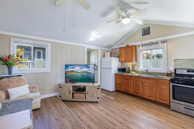 4463 Makaha Rd, Kapaa, HI 96746 - kitchen with appliances with stainless steel finishes, a ceiling fan, light wood-style floors, brown cabinets, and a sink