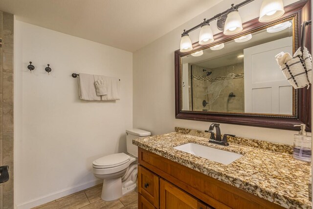 75-5865 Walua Rd Unit E631, Kailua-Kona, HI 96740 - full bathroom with a tile shower, vanity, toilet, and baseboards