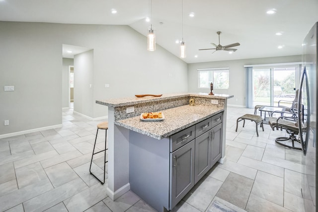 94-6661 Kamaoa Rd, Naalehu, HI 96772 - kitchen with gray cabinetry, vaulted ceiling, light stone counters, a kitchen bar, and a kitchen island