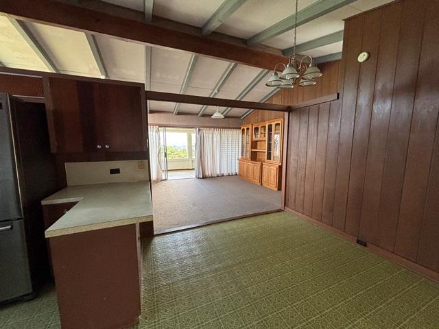 273 Iwalani St, Hilo, HI 96720 - kitchen with freestanding refrigerator, wood walls, a chandelier, hanging light fixtures, and light countertops