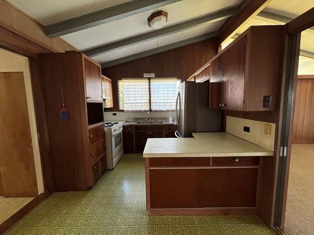 273 Iwalani St, Hilo, HI 96720 - kitchen with white gas range, freestanding refrigerator, a peninsula, light countertops, and light floors