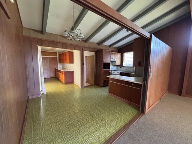 273 Iwalani St, Hilo, HI 96720 - kitchen with a chandelier, wood walls, and light countertops