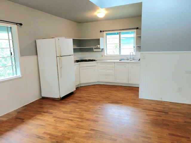 13-1128 Malama St, Pahoa, HI 96778 - kitchen with freestanding refrigerator, open shelves, a wainscoted wall, light wood-style flooring, and white cabinets